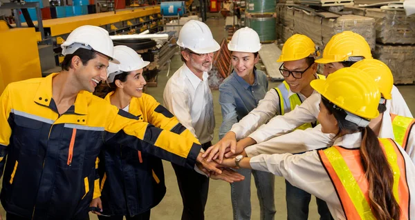 Cohesive and race diversity group of factory worker joining hands together in heavy steel industry factory exemplifying teamwork on diverse industrial engineering profession with team building concept