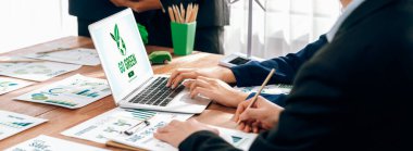 Çevreye duyarlı iş adamlarıyla yapılan ve temiz ve sürdürülebilir gelecekteki ekoloji için çevre korumasını uygulayan bir toplantıda laptopta yeşil ekoloji bilinçlendirme kampanyası yapın. Önde.