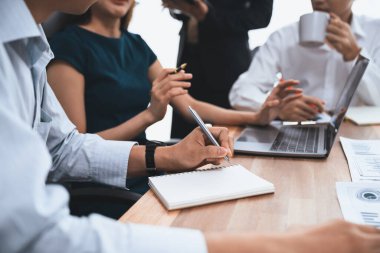 Sekreter, toplantı odasında görüşen bir grup çok ırklı iş adamıyla şirket toplantısında defterine not alıyor. Modern ofiste profesyonel toplantılarda çeşitlilik. Uyum