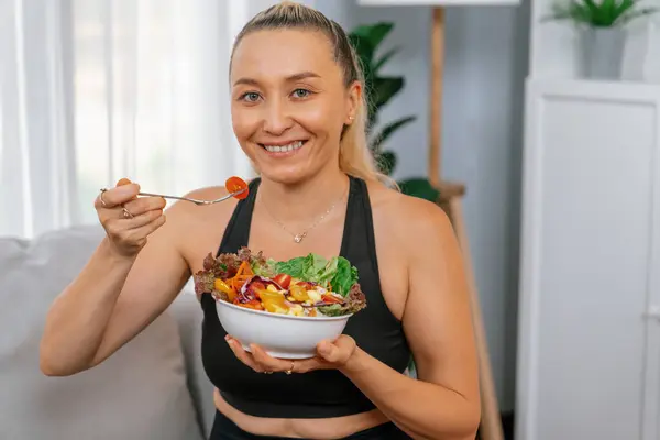 Healthy senior woman in sportswear holding a bowl of fruit and vegetable. Vegan lifestyle and healthy cuisine nutrition for fitness body physique concept. Clout