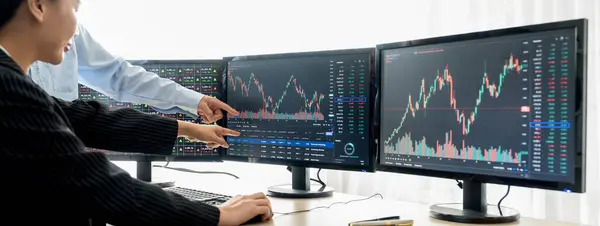 A cropped close-up image of professional smart trader hand pointing at financial growth graph while write data analysis in notebook. Business finance and Stock market investment concept. Burgeoning.