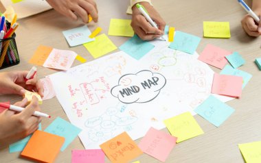 Yaratıcı bir girişim grubu beyin fırtınası fikri. Genç ve güzel iş adamları birlikte çalışıyor ve renkli yapışkan notlarla fikirleri paylaşıyorlar. Eline odaklan. Üst Manzara. Değiştirilmiş.