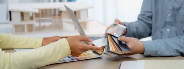 Mimar takımı iç tasarım hakkında renk paleti kullanarak tartışır. Profesyonel iç mimar, toplantı masasına yerleştirilmiş ev modeli olan müşteriye uygun rengi sunar. Değiştirilmiş.