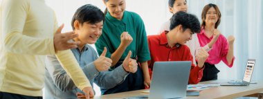 Genç yaratıcı iş ekibinin kırpılmış görüntüsü başarılı iş planını toplantı masasına dizüstü bilgisayar ve iş belgeleriyle kutluyor. Yaratıcı ve başarılı başlangıç konsepti. Değiştirilmiş.