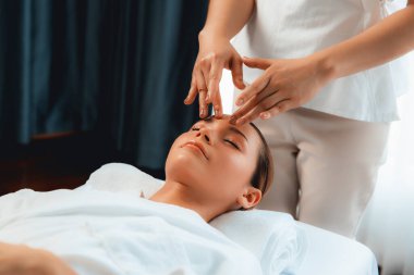 Kafkasyalı kadın stres önleyici kafa masajından ve lüks tatil beldesi ya da otel spa salonundaki modern ışık ortamında yüz güzelliği eğlencelerini şımartmaktan hoşlanıyor. Sessiz.