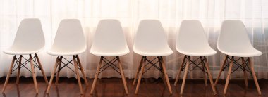 Şirket şirketinde iş görüşmesi için bekleme odasında modern ofis sandalyesinin boş sırasının panoramik çekimi. Salon içi ofis mobilyaları. Koridordaki beyaz koltuğun önünde çok az tasarım var. Önde.