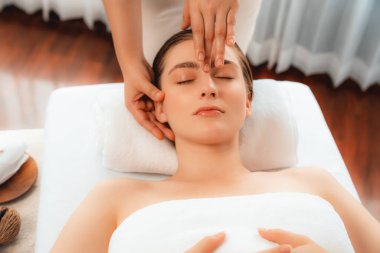 Kafkasyalı kadın stres önleyici kafa masajından ve lüks tatil beldesi ya da otel spa salonundaki modern ışık ortamında yüz güzelliği eğlencelerini şımartmaktan hoşlanıyor. Sessiz.