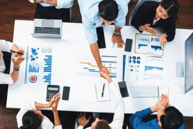 Üst düzey ofis çalışanları stratejik iş pazarlama toplantısı üzerine anlaşma yaptıktan sonra el sıkışıyor. Takım çalışması ve olumlu tutum verimli ve destekleyici bir iş yeri yaratır. Tedbirli