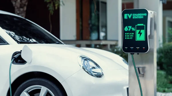 Ev充電ケーブルでバッテリーを充電するためにホーム充電ステーションに接続された電気自動車 将来の革新的なEv車とエネルギー持続可能性 スマートかつ未来的な家庭用エネルギーインフラ Peruse — ストック写真