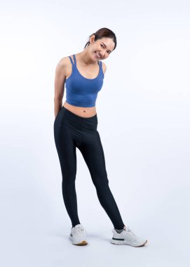 Spor giyim portresindeki tüm vücut Asyalı kadın gülümsüyor ve neşeli bir jest yapıyor. Çekici bir kızla egzersiz yapmak sağlıklı yaşam tarzını sürdürmeye yöneliktir. İzole edilmiş arka plan Vigorous