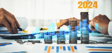 Büyüyen madeni para yığını iş yatırımını ve ekonomik büyümeyi simgeliyor. Finansal hedefe ulaşmak ve 2024 yılına maksimum kar sağlamak için finansal planlama yapan iş adamları. Kurnaz.