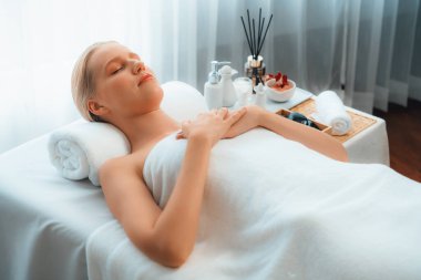 Kafkasyalı kadın müşteri stres önleyici spa masajının keyfini çıkarıyor ve lüks otel ya da oteldeki gündüz açık ortam güzellik salonunda güzellik teniyle eğleniyor. Sessiz.