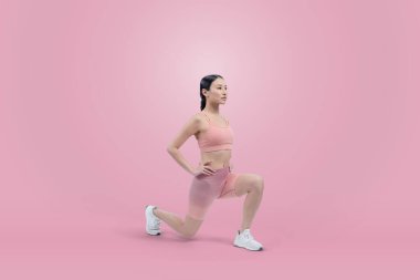 Spor giyimli çekici Asyalı kadın spor egzersizlerinden önce esneme hareketleri yapıyor. Stüdyo çekimlerinde ısınan atletik bir kadınla sağlıklı vücut bakımı egzersizi. Kuvvetli