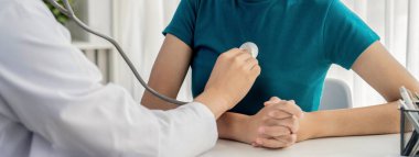 Hasta klinikte ya da hastane ofisinde doktor randevusuna gidiyor. Hastaların nabzını steteskopla kontrol ederken, doktor semptomları muayene ediyor ve teşhis ediyor. Panorama Katı