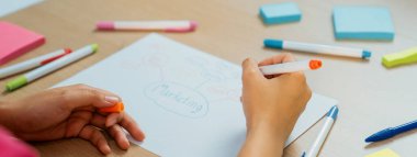 Profesyonel iş kadını iş dünyasının zihin haritasını çiziyor. Yaratıcı kadın girişim lideri, fikir üretmek için kalem ve yapışkan notlar kullanarak pazarlama planları hazırlıyor. - Yakın çekim. Eline odaklan. Değiştirilmiş.