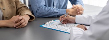 Doktor, doktor muayenehanesindeki genç çifte tıbbi teşhis raporu ve şefkat dolu sağlık hizmetleri konsültasyonu göster. Doktor randevusu ve tıbbi danışma konsepti. Neoterik