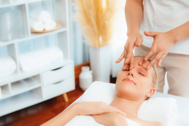 Kafkasyalı kadın stres önleyici kafa masajından ve lüks tatil beldesi ya da otel spa salonundaki modern ışık ortamında yüz güzelliği eğlencelerini şımartmaktan hoşlanıyor. Sessiz.