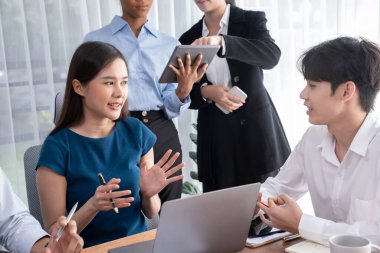 Mutlu iş adamları birlikte çalışır, şirket ofisinde tartışırlar. Profesyonel ve çeşitlilik takım çalışması iş planını bilgisayarda tartışır. Modern çok kültürlü ofis çalışanı. Uyum