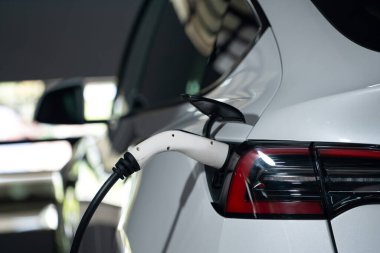 Alış veriş merkezinin otoparkında EV elektrikli araba şarjı şehir merkezindeki sürdürülebilirlik yaşam tarzını yeşil, temiz, yeniden şarj edilebilir elektrikli araç iç organları ile gösteriyor.