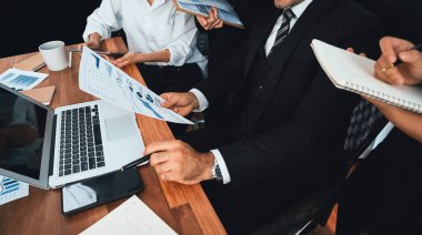 Ofis masasındaki finansal veri raporlarını analiz eden çeşitli bir grup iş analisti. Stratejik pazarlama planlaması için iş istihbarat analizine göre grafikler ve grafikler.
