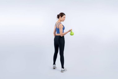 Dinç, enerjik bir kadın izole edilmiş arka planda ağırlık kaldırma egzersizi yapıyor. Genç atletik Asyalı kadın dayanıklılığı ve dayanıklılık eğitimi rutin vücut egzersizi..