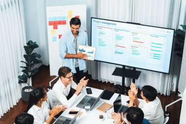 Proje yöneticisi monitörde proje yönetimi yazılım görüntülemesi, proje görevinin ilerlemesini izlemek ve toplantı masasında program planı yapmak suretiyle ekiple iletişim kurar ve işbirliği yapar. Tedbirli