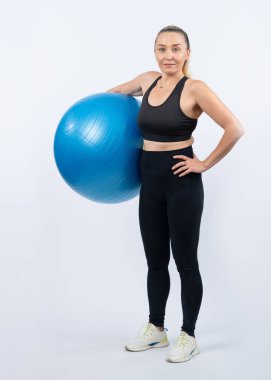 Vücut uzunluğu tam, atletik ve sportif yaşlı bir kadın izole edilmiş arka planda spor topuyla egzersiz yapıyor. Emeklilikten sonra sağlıklı ve aktif bir yaşam tarzı. Etki
