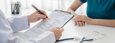 Klinikteki ya da hastane ofisindeki doktor randevusuna katılan hasta, tıbbi tedavi seçeneklerini tartışıyor ve muayene sonuçlarını ya da hastalıkla ilgili tıbbi kayıtları açıklıyor. Panorama Katı