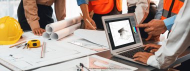 Mühendis ve mimar birlikte çalışarak ayrıntılı bir dijital iç mimari ya da yapı tasarımı için dizüstü bilgisayar kullanarak beyin fırtınası yapıyor ve tasarım yapıyor. İçgörü