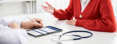 Klinikteki ya da hastane ofisindeki doktor randevusuna katılan hasta, tıbbi tedavi seçeneklerini tartışıyor ve muayene sonuçlarını ya da hastalıkla ilgili tıbbi kayıtları açıklıyor. Panorama Katı