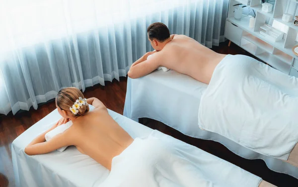 Top view caucasian couple customer enjoying relaxing anti-stress spa massage and pampering with beauty skin recreation leisure in day light ambient salon spa at luxury resort or hotel. Quiescent