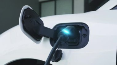 Elektrikli araba, gelecekteki ev şarj istasyonunda akıllı dijital EV batarya durumu hologramıyla şarj oluyor. EV arabasının teknolojik gelişimi ve sürdürülebilir gelecek için ev enerjisi altyapısı. İncelenme