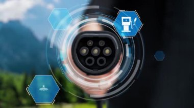 Kameranın önündeki EV şarj cihazına odaklan. Çevre dostu enerji altyapısı ikonu, bulanık doğal arkaplana sahip hologram görüntüsü. CO2 emisyon EV otomobili için alternatif temiz enerji.