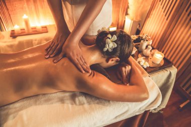 Beyaz kadın müşteri stres önleyici spa masajının keyfini çıkarıyor ve lüks otel ya da otelde sıcak mum ışığında güzellik teniyle eğleniyor. Sessiz.