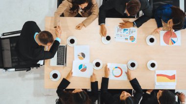 İş adamları grup toplantısı ofiste yukarıdan çekildi. İş kadınları, iş adamları ve ofis çalışanları toplantı masasında proje planlama belgeleriyle takım konferansında çalışıyorlar. Jivy