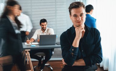 Ofiste çalışan iş arkadaşı ve iş adamlarının bulanık hareketli geçmişine sahip güler yüzlü iş adamı portresi. Ofis çalışanı takım çalışması ve pozitif iş yeri konsepti. Tedbirli