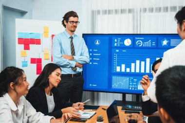 İş adamı, finansal rapor veri analizi veya pazar eğilimi gösterisiyle iş sunumunu şirketin gelecekteki yönetiminde stratejik planlama için büyük bir TV ekranında sundu. Habiliment