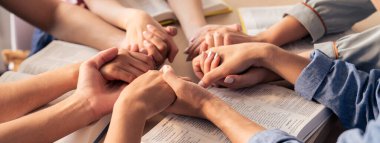 İncildeki ahşap kilisede insanların el ele dua ederken inançla el ele tutuşmalarının kırpılmış görüntüsü. Umut kavramı, din, inanç, Tanrı 'nın lütfu kavramı. Filizlenen.