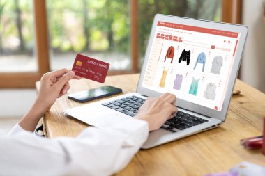 İnternet pazarından alışveriş yapan kadın modern yaşam tarzı için satış malzemeleri arıyor ve en yüksek siber güvenlik yazılımı tarafından korunan cüzdandan çevrimiçi ödeme için kredi kartı kullanıyor