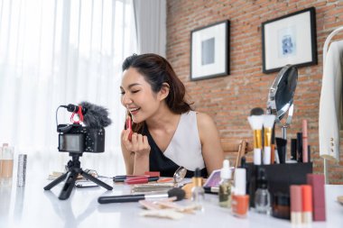 Kadın Etkilenen Vlog video görüntülerini canlı olarak çekiyor. Makyajın çoğu sosyal medya ya da blog 'u anlatıyor. Kozmetik stüdyosu ışıklandırmalı mutlu genç kız çevrimiçi pazarlama oturumu yayını için..