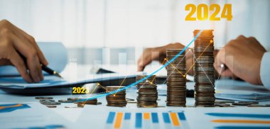 Büyüyen madeni para yığını iş yatırımını ve ekonomik büyümeyi simgeliyor. Finansal hedefe ulaşmak ve 2024 yılına maksimum kar sağlamak için finansal planlama yapan iş adamları. Kurnaz.