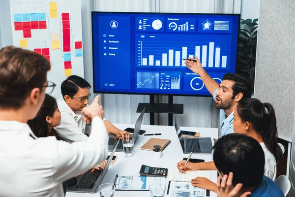 Analyst team utilizing BI Fintech to analyze financial data at table in meeting room. Businesspeople analyzing BI dashboard power for business insight and strategic marketing planning. Prudent