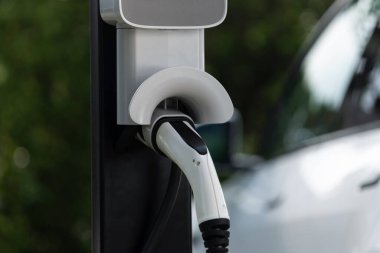 Platform enerji sosunu şarj etmek için şarj prizi takılı EV şarj istasyonu kapatıldı. Daha iyi bir gelecek için çevre dostu EV araba için alternatif temiz ve sürdürülebilir enerji. Eşzamanlama