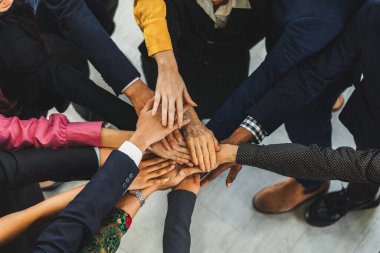 A group of diversity people putting their hands together. Showing unity teamwork and friendship. Close up top view of young business man and business woman joining as a team. Intellectual. clipart