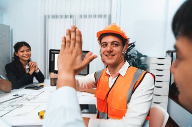 Çeşitli inşaat mühendisi ve müvekkil grupları, mimari proje üzerinde başarılı bir anlaşma yaptıktan, inşaat planını gözden geçirdikten ve toplantı masasında plan oluşturduktan sonra kutlama ve beşlik çakışma yaptılar.