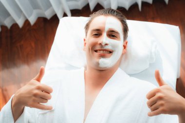 Kaplıca salonunun sakin atmosferi, insan müşterisi modern gün ışığında lüks yüz kremi masajıyla kendini yenileme zevkine kapılıyor. Yüz bakımı ve güzellik konsepti. Sessiz.