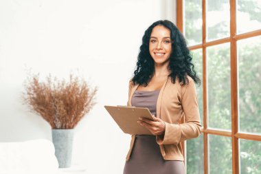 Klinikteki psikolog kadın. Profesyonel portresi. Dostane gülümsemesiyle hastayı psikoloğa davet ediyor. Deneyimli ve kendinden emin psikolog çok önemli bir uzmandır.