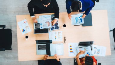 İş adamları grup toplantısı ofiste yukarıdan çekildi. İş kadınları, iş adamları ve ofis çalışanları toplantı masasında proje planlama belgeleriyle takım konferansında çalışıyorlar. Jivy