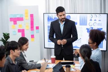 Pazarlama stratejisi için modern toplantıda veri analizi paneli ekranında sunan bir işadamı. Bir grup iş adamıyla konferans odasında iş sunumu. Uyum