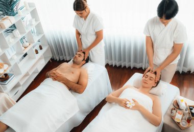 Kafkasyalı çift stres önleyici kafa masajının keyfini çıkarıyor ve lüks otellerde ya da otel spa salonlarında gündüz kaplıcalarında yüz güzelliği eğlencelerini şımartıyor. Sessiz.